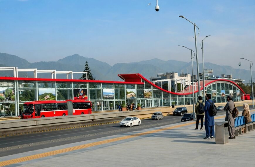 Islamabad metro bus at a station with Margalla Hills in the background